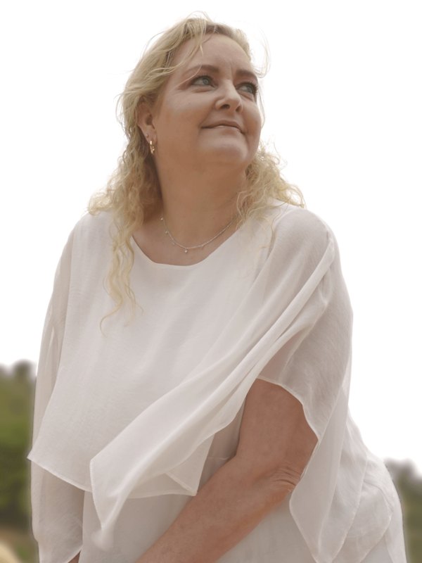 Lady Tabitha in a white blouse, smiling and looking up