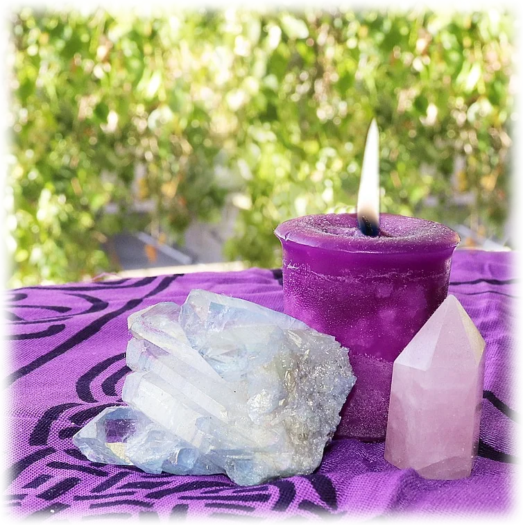 A purple candle and crystals on a table in the garden